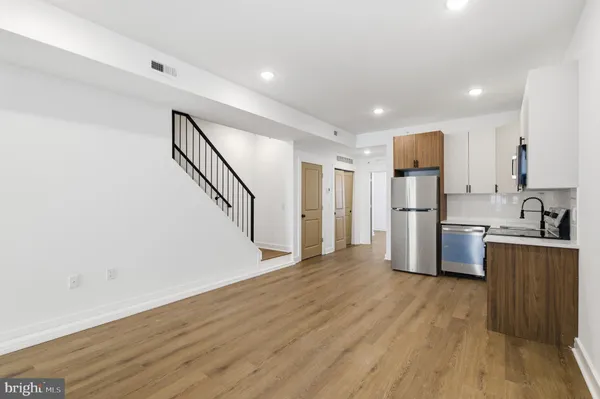 a view of kitchen with wooden floor and electronic appliances