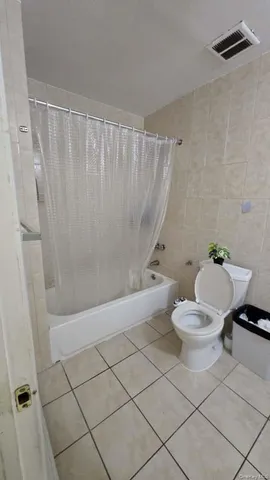 a white toilet sitting next to a bath tub and shower