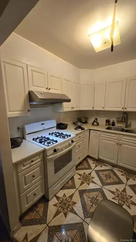 a kitchen with granite countertop a stove and a sink