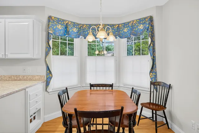 a kitchen with a table chairs a sink dishwasher window and cabinets
