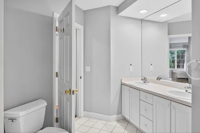 a bedroom with a bed and a lamp on dresser