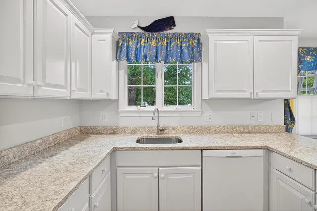 a kitchen with a sink cabinets and window