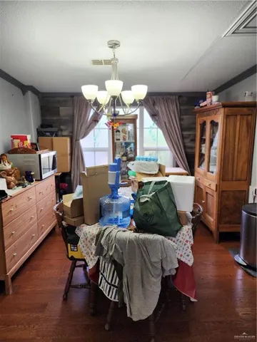 a living room with furniture kitchen view and a chandelier