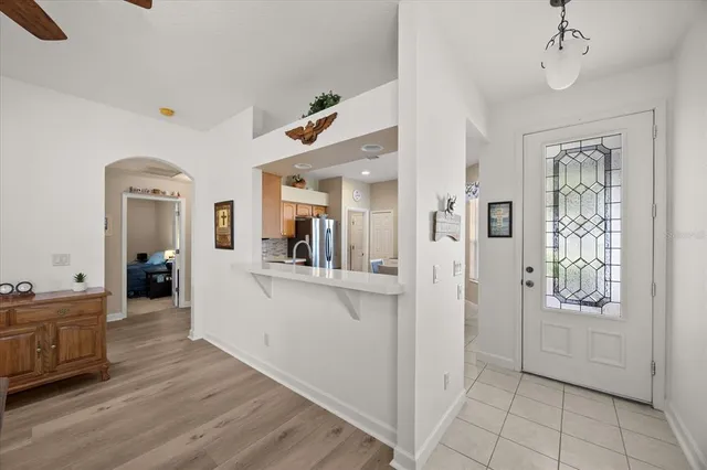 a view of a hallway with wooden floor and a living room