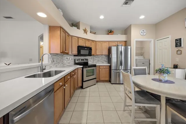 a kitchen with stainless steel appliances granite countertop a sink refrigerator and cabinets