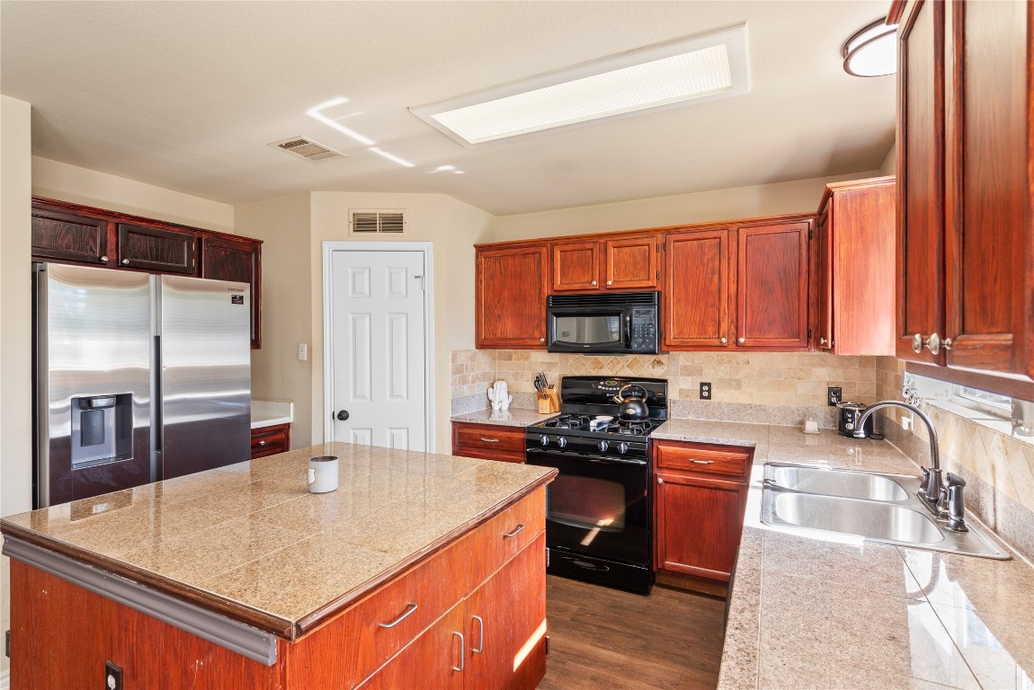 1111 Pathfinder Way Round Rock, TX 78665 - Photo 12 of 40 a kitchen with stainless steel appliances granite countertop a sink a stove and a refrigerator