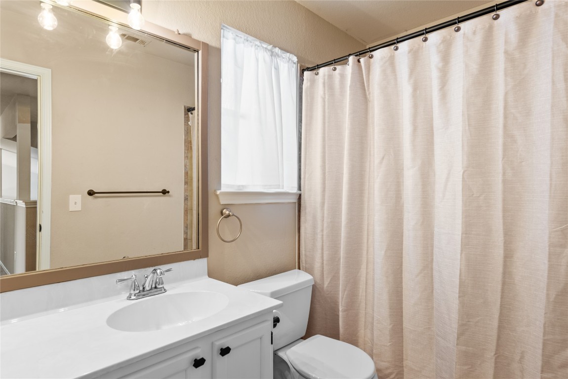 1111 Pathfinder Way Round Rock, TX 78665 - Photo 18 of 40 a bathroom with a sink a toilet and shower curtain