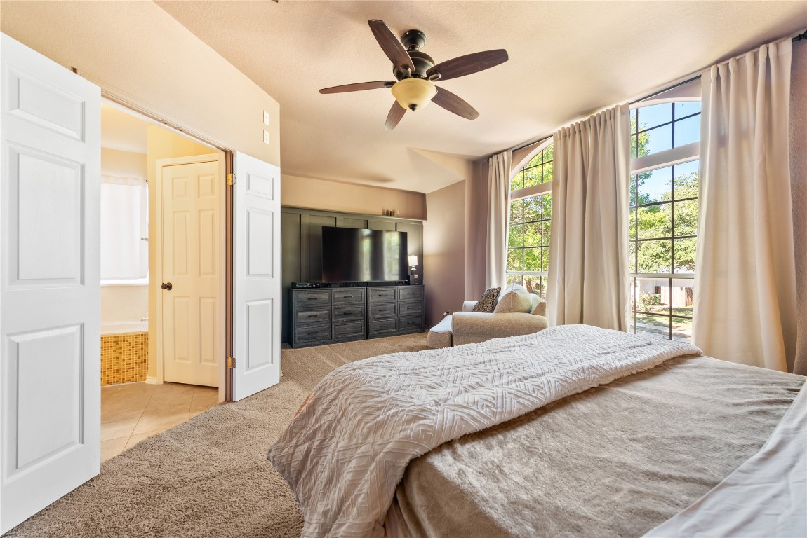 1111 Pathfinder Way Round Rock, TX 78665 - Photo 20 of 40 a bedroom with a balcony a bed and a television