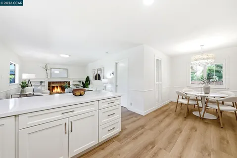 a living room with stainless steel appliances kitchen island furniture and wooden floor