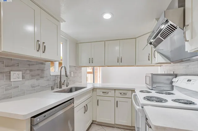 a kitchen with white cabinets and white appliances
