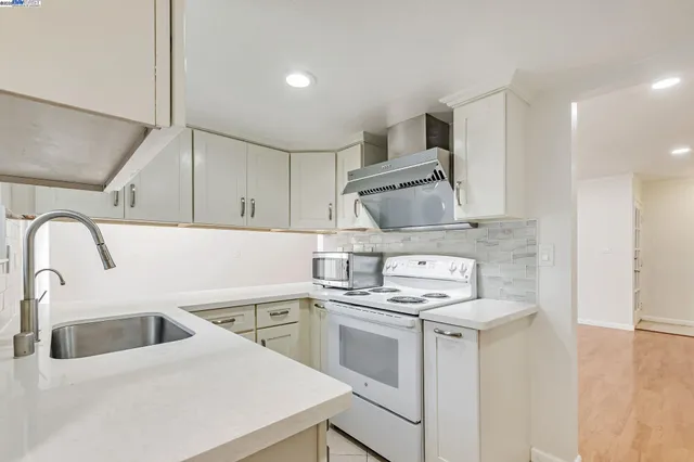 a kitchen with a sink a stove and cabinets