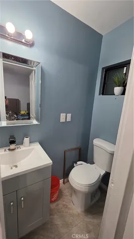 a bathroom with a toilet a sink a mirror and vanity
