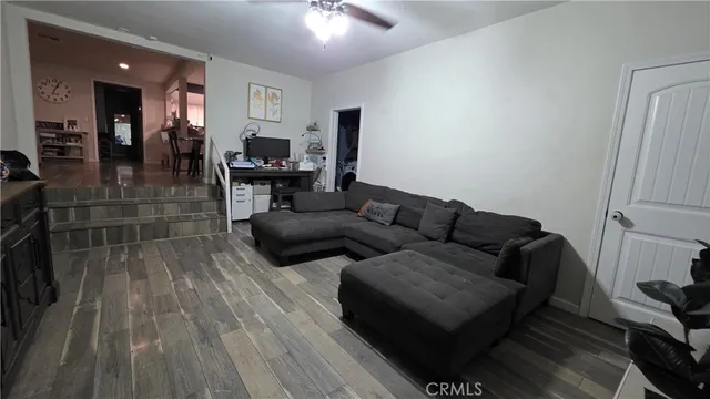 a living room with furniture and a wooden floor