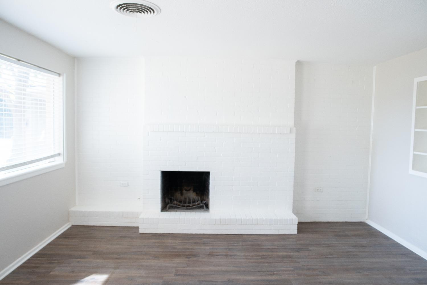 5522 13th Street, Unit A Lubbock, TX 79416 - Photo 4 of 11 a view of a livingroom with wooden floor and a fireplace
