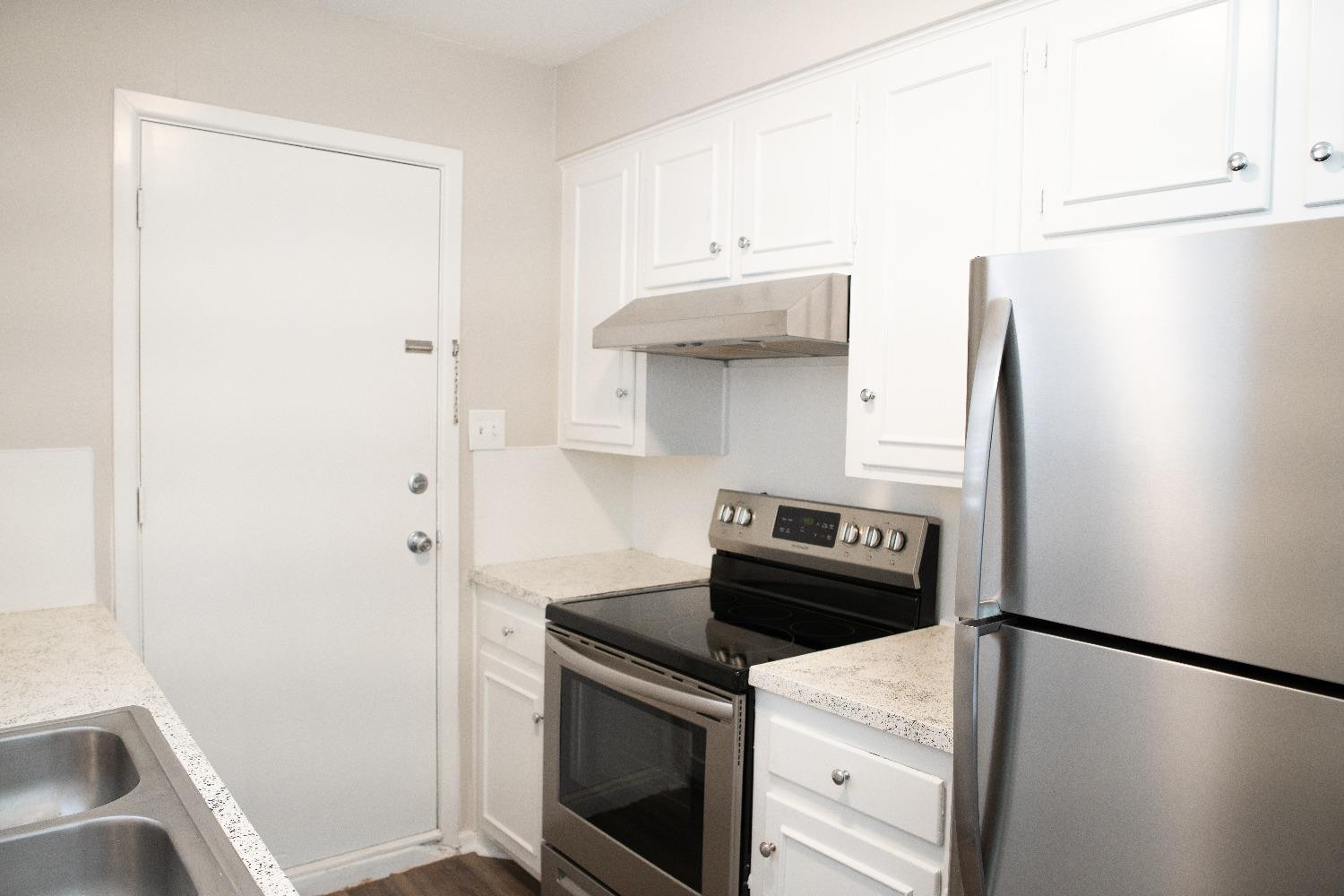 5522 13th Street, Unit A Lubbock, TX 79416 - Photo 5 of 11 a kitchen with a refrigerator and a stove