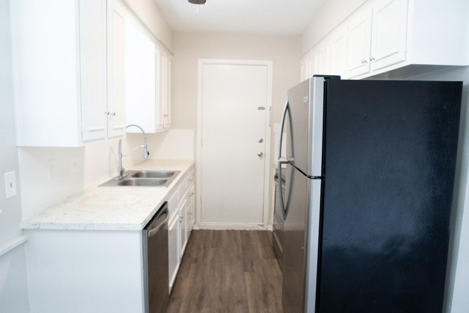 5522 13th Street, Unit A Lubbock, TX 79416 - Photo 6 of 11 a kitchen with a sink and a refrigerator