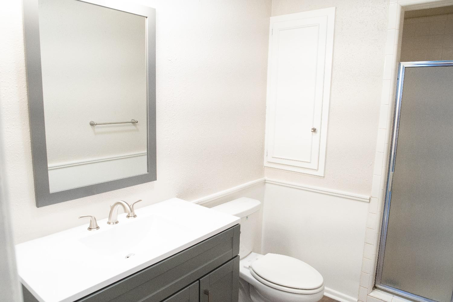 5522 13th Street, Unit A Lubbock, TX 79416 - Photo 8 of 11 a bathroom with a sink a toilet and shower