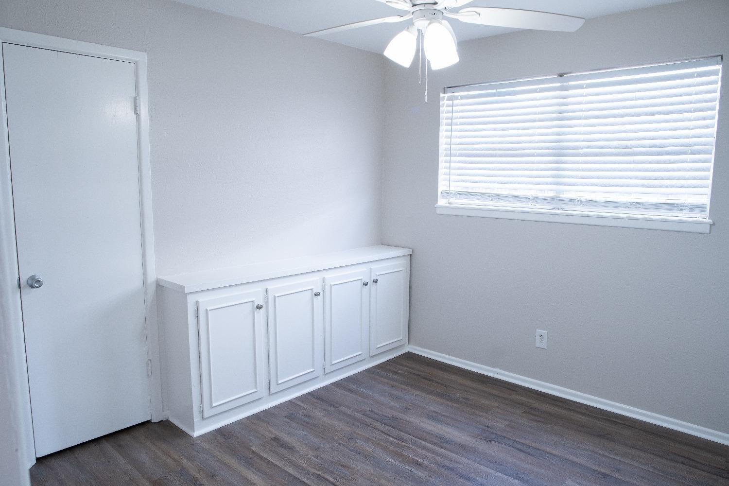 5522 13th Street, Unit A Lubbock, TX 79416 - Photo 9 of 11 an empty room with wooden floor and windows