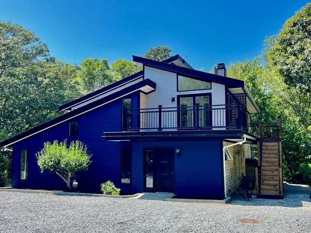 a view of a bedroom with a bed and chandelier fan