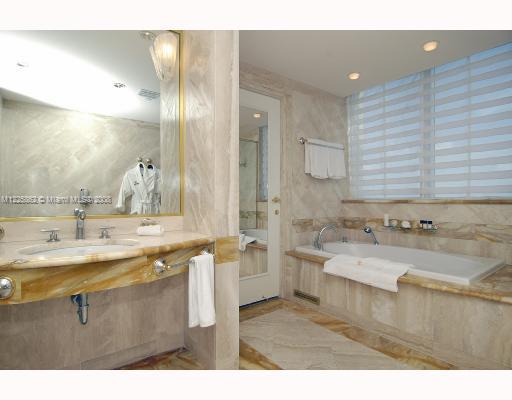 101 Ocean Drive, Unit 807 Miami Beach, FL 33139 - Photo 7 of 8 a bathroom with a sink double vanity granite tub shower and a mirror