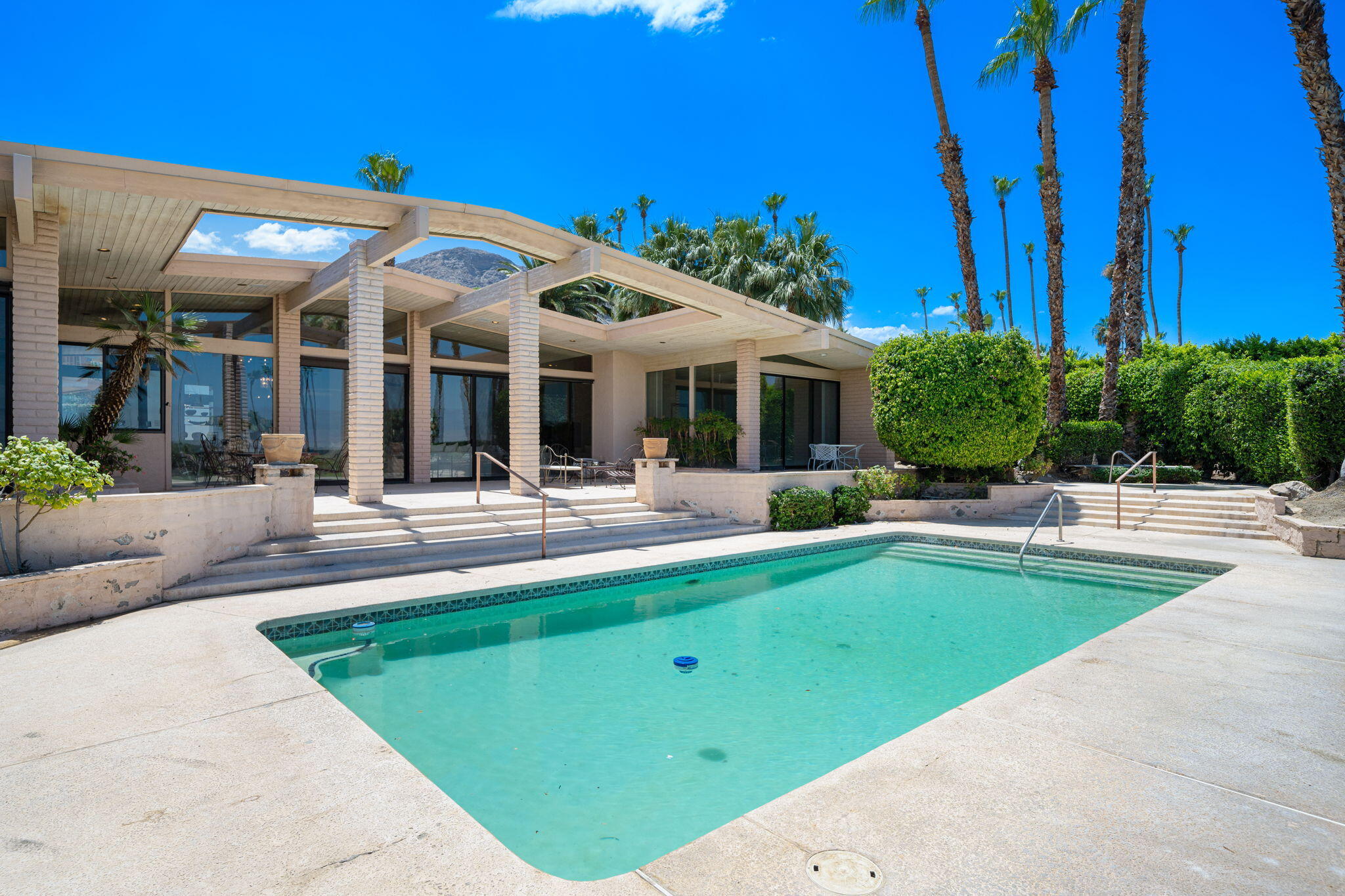 70465 Pecos Road Rancho Mirage, CA 92270 - Photo 33 of 48 a view of a house with swimming pool and a table and chairs