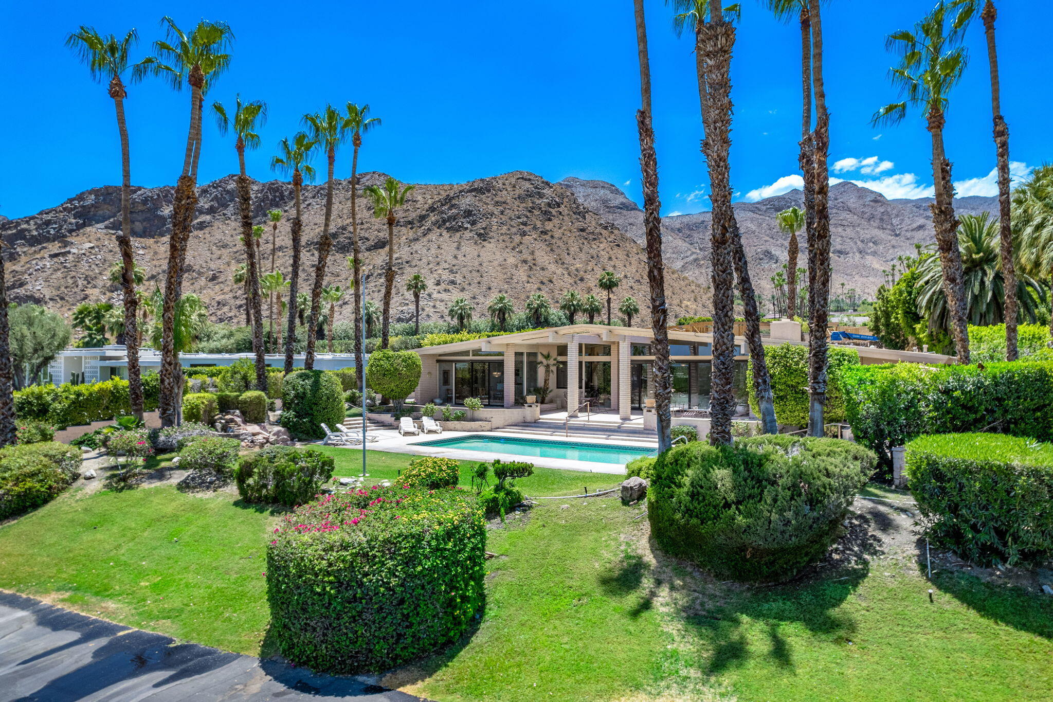 70465 Pecos Road Rancho Mirage, CA 92270 - Photo 4 of 48 a view of a house with a garden and swimming pool
