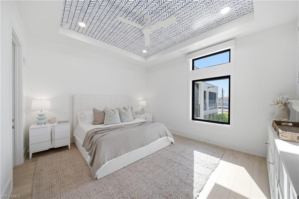82 9th Street South, Unit 303 Naples, FL 34102 - Photo 13 of 26 a bedroom with a bed and a lamp