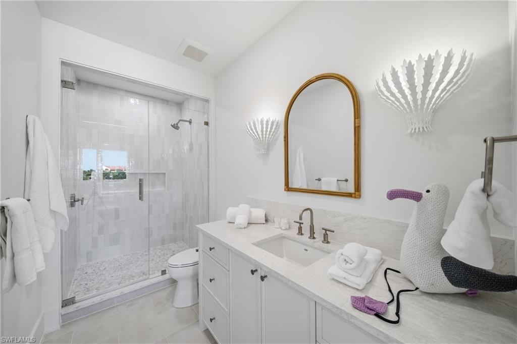 82 9th Street South, Unit 303 Naples, FL 34102 - Photo 16 of 26 a bathroom with a double vanity sink mirror and shower