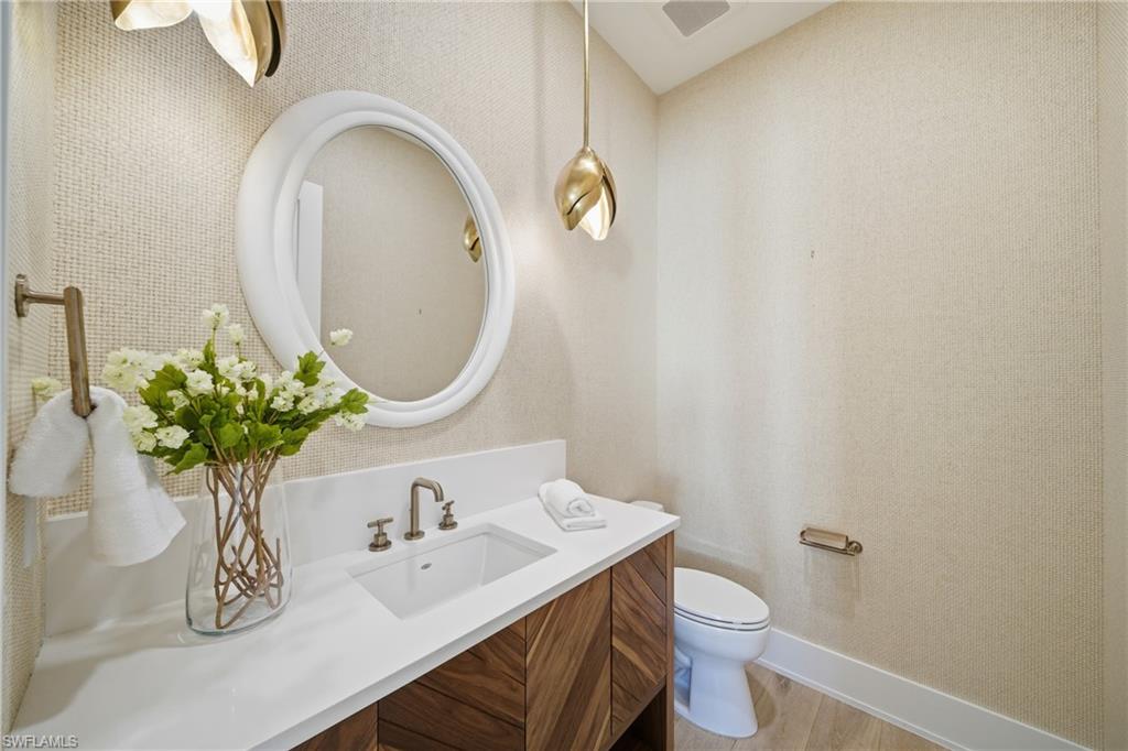 82 9th Street South, Unit 303 Naples, FL 34102 - Photo 17 of 26 a bathroom with a toilet sink and mirror