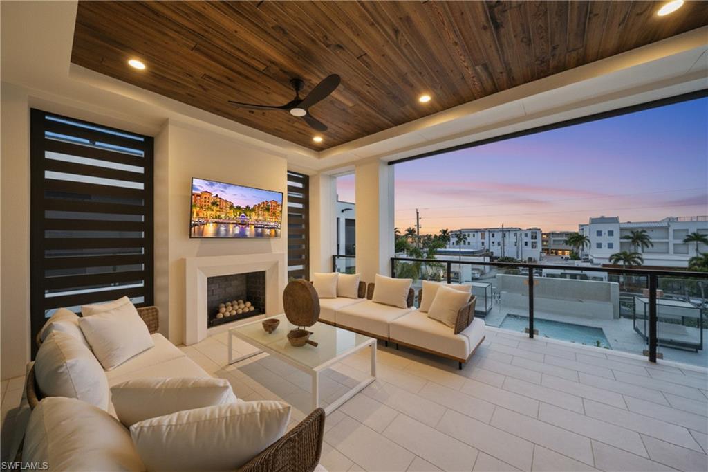 82 9th Street South, Unit 303 Naples, FL 34102 - Photo 25 of 26 a outdoor living space with furniture and a fireplace