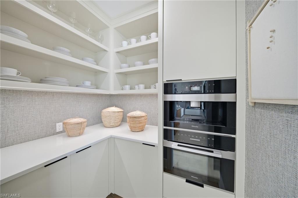 82 9th Street South, Unit 303 Naples, FL 34102 - Photo 5 of 26 a kitchen with a shelf and a wooden floor