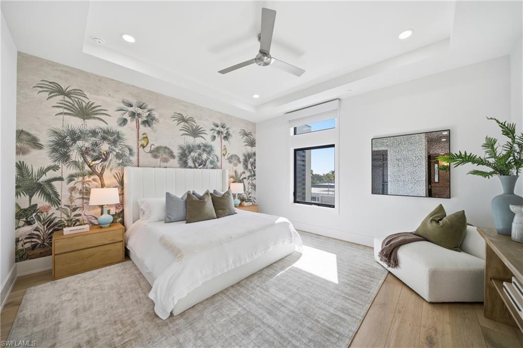 82 9th Street South, Unit 303 Naples, FL 34102 - Photo 9 of 26 a bedroom with a large bed couch and a window