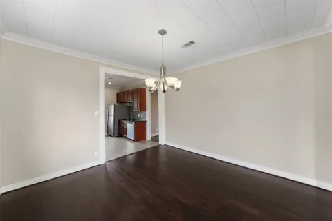 a view of a room with wooden floor chandelier and closet