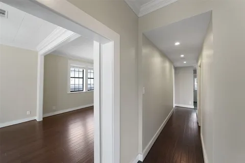 a view of a hallway with wooden floor and windows