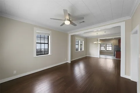 a view of an empty room with a window and wooden floor