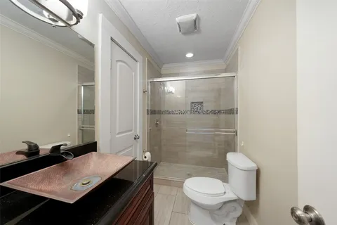 a bathroom with a sink a toilet a mirror and shower