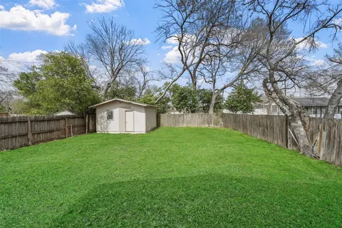 a view of a house with backyard and trees