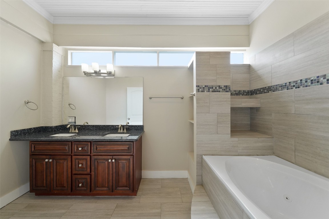309 Pecore Street Houston, TX 77009 - Photo 8 of 45 a bathroom with a granite countertop bathtub a sink and a mirror