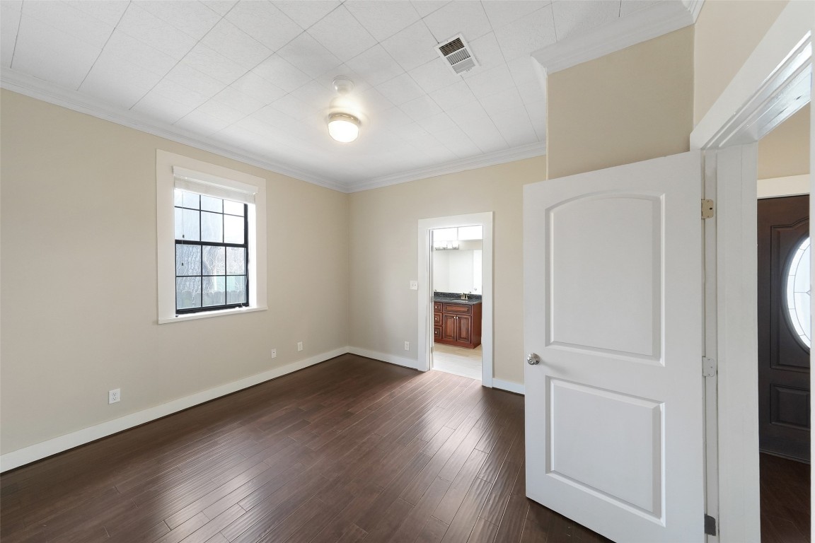309 Pecore Street Houston, TX 77009 - Photo 9 of 45 an empty room with wooden floor cabinet and windows