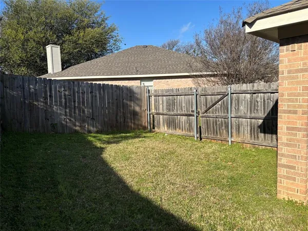 a view of a backyard with a wooden fence