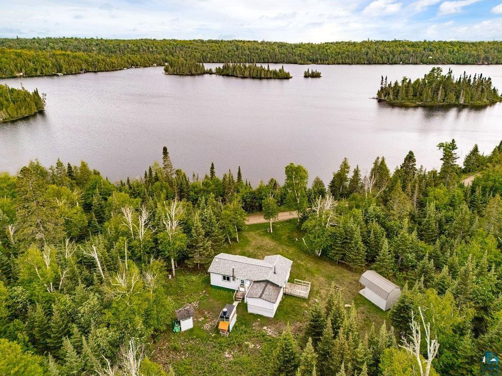 1268 Tom Lake Road Hovland, MN 55606 - Photo 2 of 56 Lakeside property featuring a single-story residence with a gray shingle roof and a wooden deck