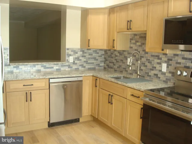 a kitchen with stainless steel appliances white cabinets and a sink