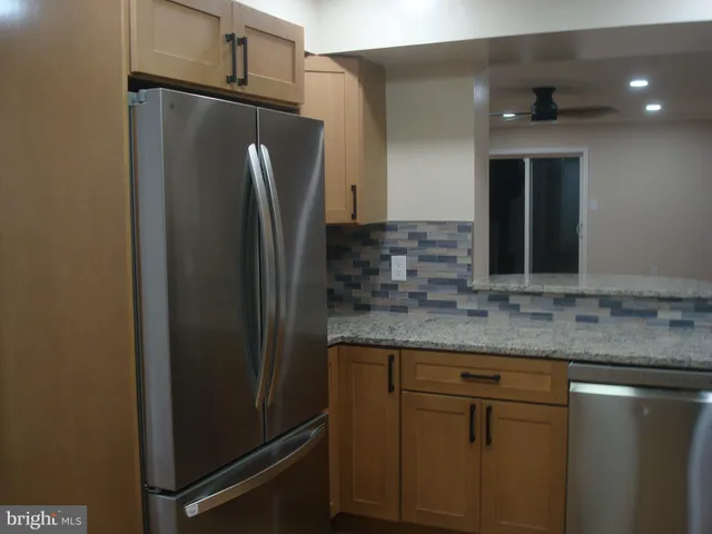 a kitchen with stainless steel appliances granite countertop a refrigerator and a sink