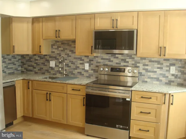 a kitchen with stainless steel appliances white cabinets and a sink