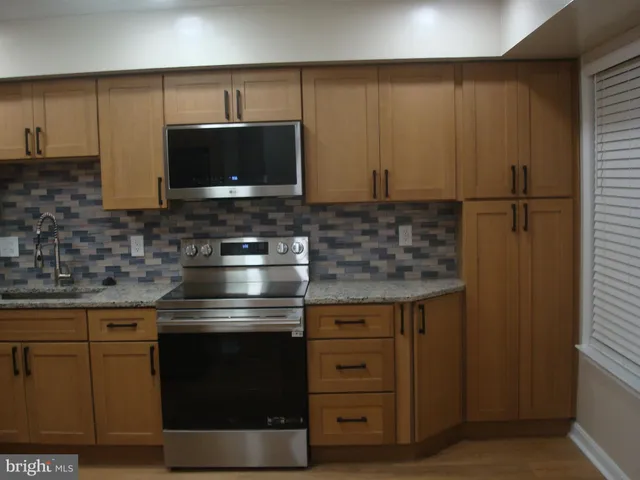 a kitchen with stainless steel appliances granite countertop a stove and a microwave oven