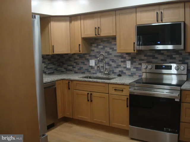 a kitchen with stainless steel appliances granite countertop a stove and a microwave