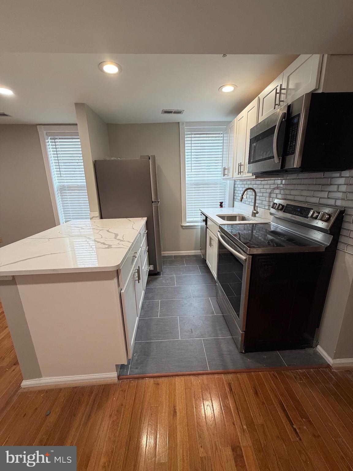 1458 Riverside Avenue, Unit 2B Baltimore, MD 21230 - Photo 6 of 16 a kitchen with a sink a stove top oven and cabinets