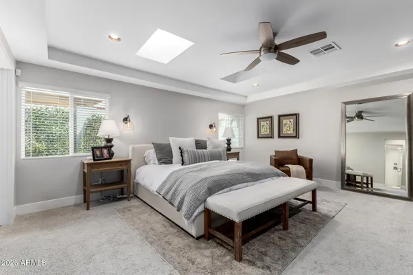 a spacious bedroom with a bed and a chandelier