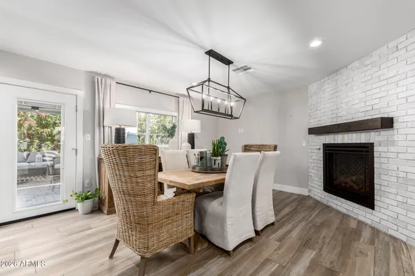 a dining room with furniture a fireplace and wooden floor