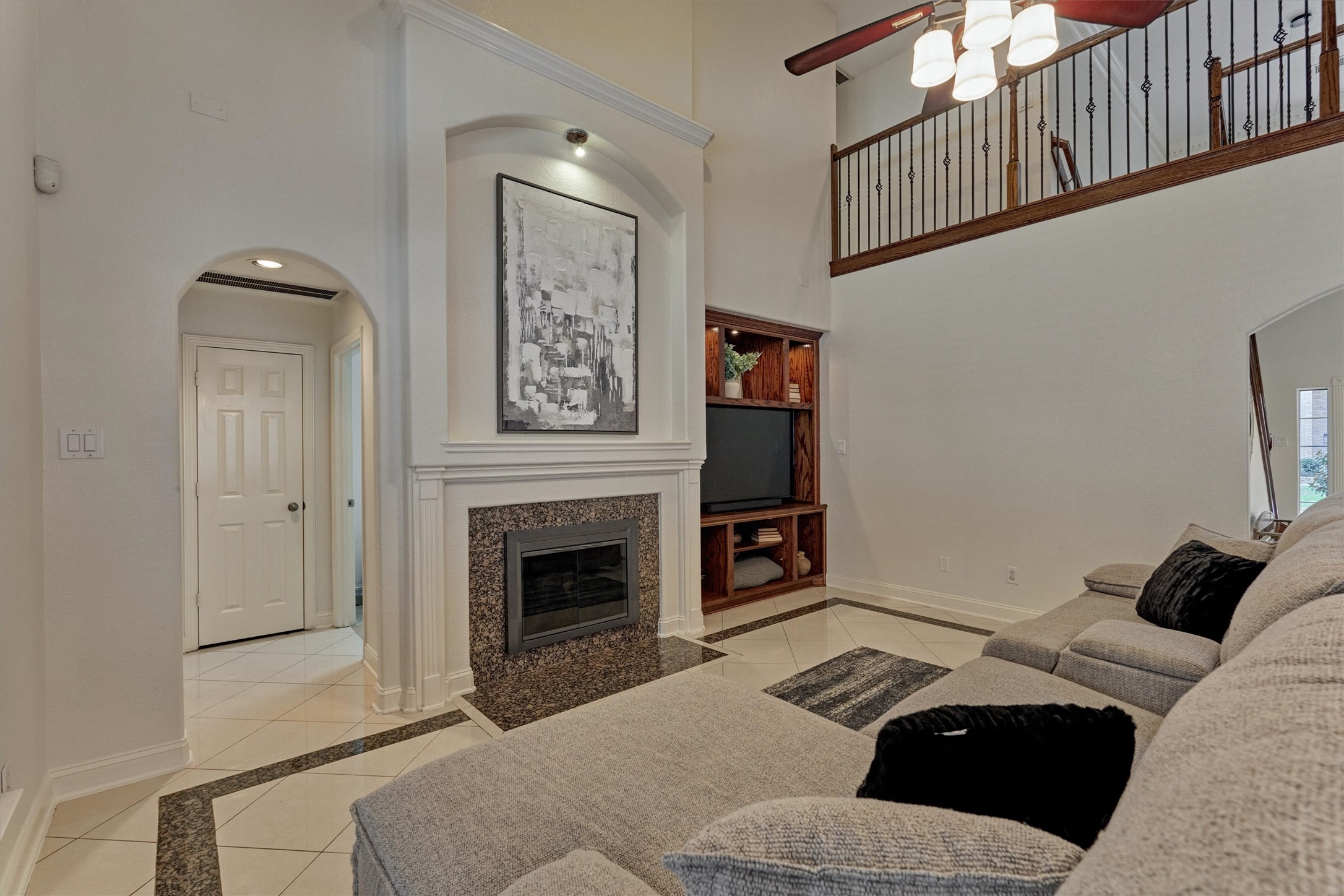 20938 Thistleberry Lane Spring, TX 77379 - Photo 19 of 45 Living room - arched hallway leads to laundry on right, primary suite on left and storage closet.